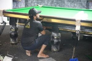 Professional snooker table installation process showing slate leveling and setup