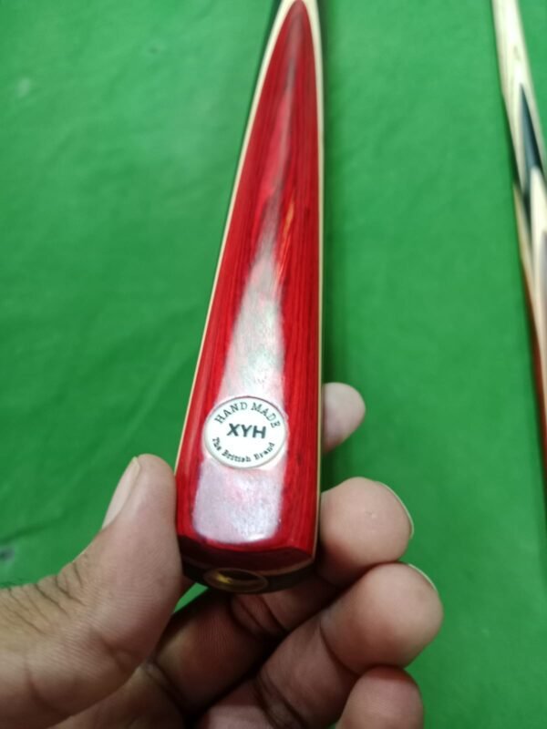The XYH Handmade Snooker Cue, a premium professional cue stick crafted with precision, is designed for serious players who demand quality and performance. Featuring a 57 inch length, an 18oz balanced weight, and a 9.5mm tip size, this 3 piece snooker cue offers excellent control, spin, and accuracy. Made from high-quality ash wood, with a strong butt design, elegant red butt finish, and ebony splices, it combines both style and durability. The brass joint ensures long-lasting strength, while the smooth finishing provides a comfortable grip for consistent play. Whether you are looking for a professional snooker cue, handmade cue stick, billiard cue stick, or personal snooker cue, the XYH model is one of the best snooker cues in Pakistan, perfect for home, clubs, or tournaments.