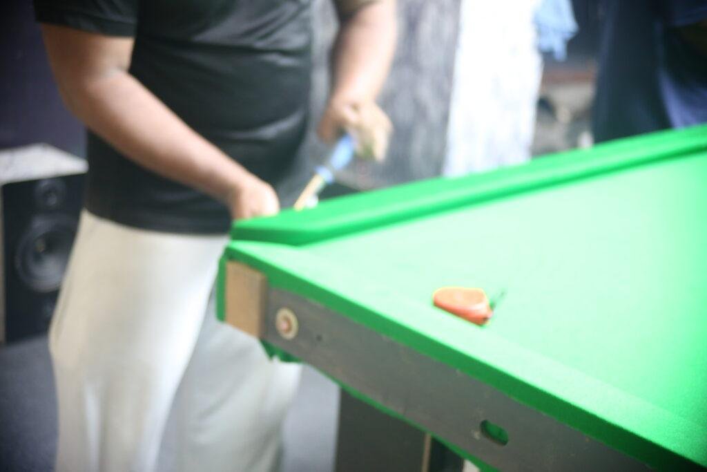 Professional snooker table installation process showing slate leveling and setup